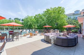 A patio with a table and chairs and umbrellas.